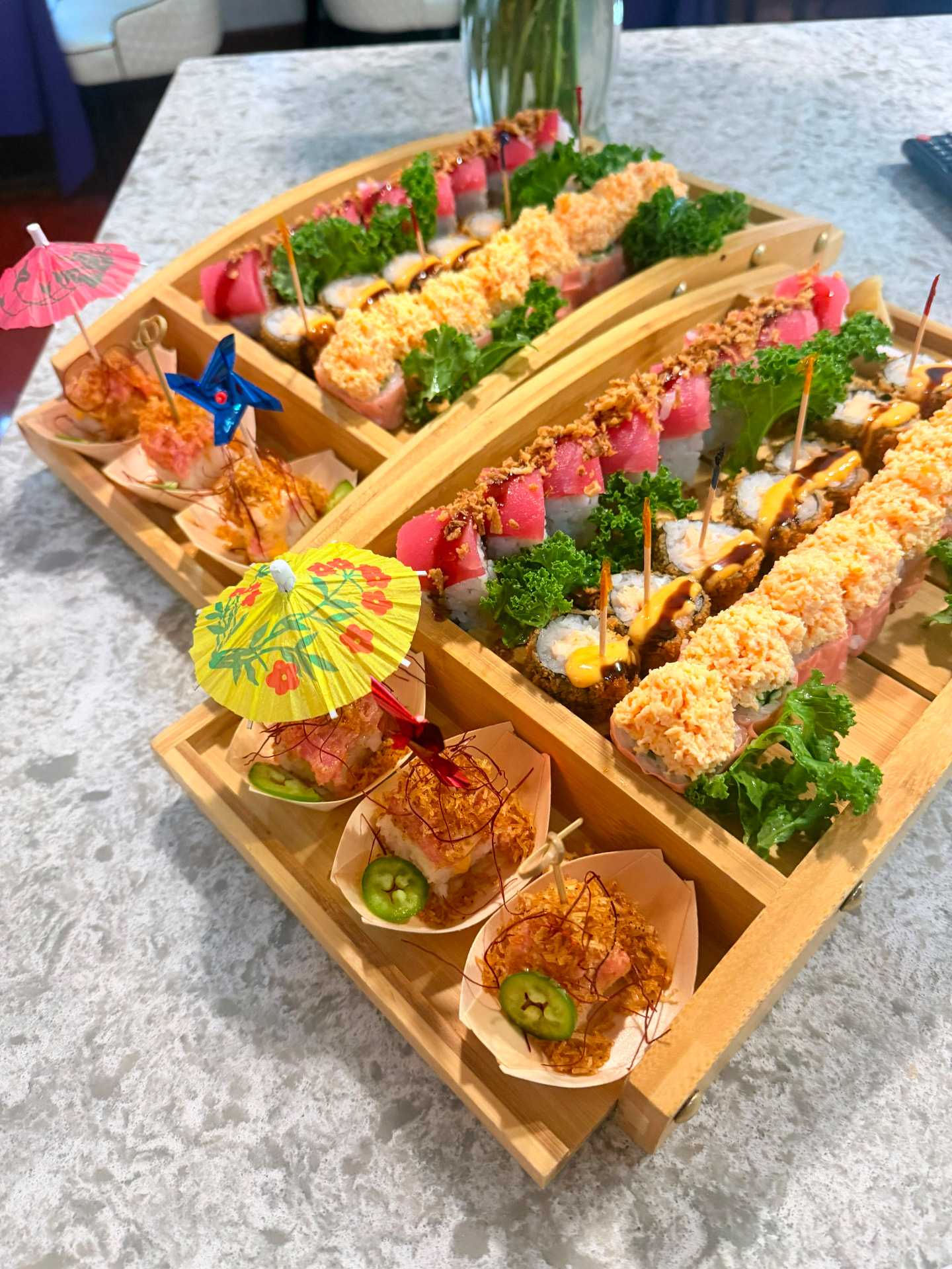 Wooden sushi boats filled with signature rolls and bites